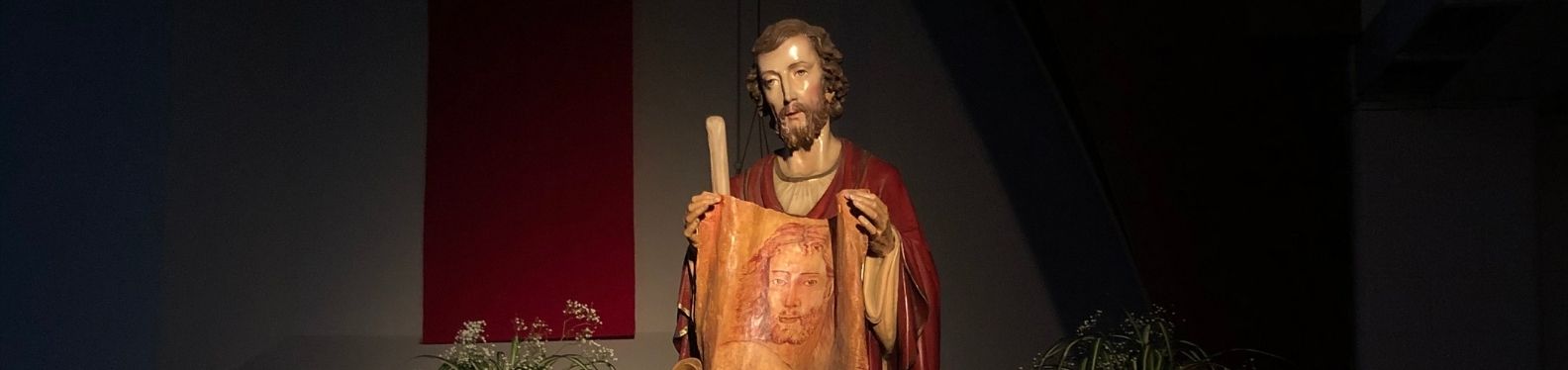 Photo of a St. Jude's statue zoomed on the face of St. Jude holding a cloth with Christ's face.
