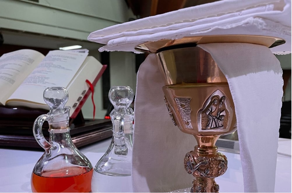 Gold Chalice and Cruets on the altar with the Roman Missal in the background.
