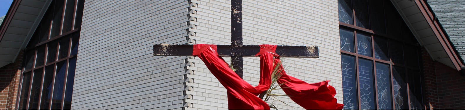 Wooden Cross outside on St. Jude's lawn with red cloth draped on both sides