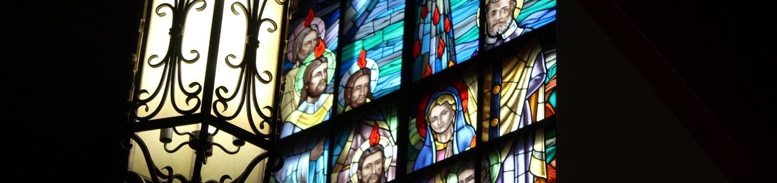 Photo of St. Jude's Pentecost stain glass window displaying the apostle receiving the holy spirit on Pentecost.
