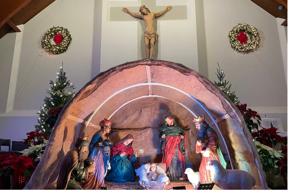 Manager with Mary, Joseph, and Jesus. With the Main Crucifix of St. Jude's in the background with two wreaths on both sides light up.